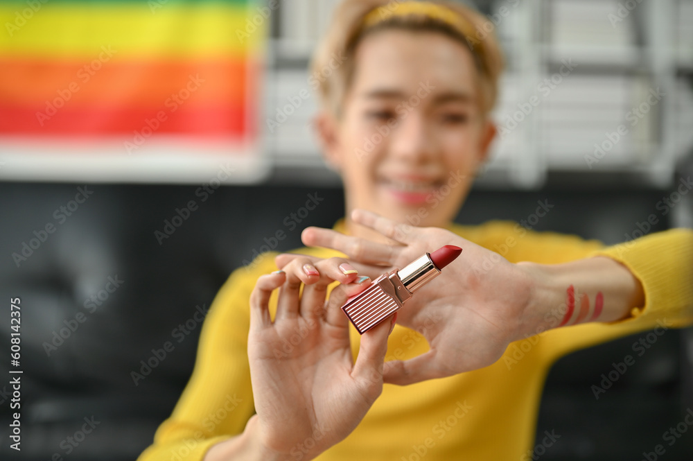 An attractive young Asian gay beauty influencer reviewing and showing his new lipstick An attractive young Asian gay beauty influencer reviewing and showing his new lipstick