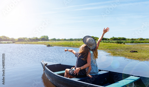 Family on wooden row boat in river ( Briere marsh, Marais de briere, France, Pays de la Loire)