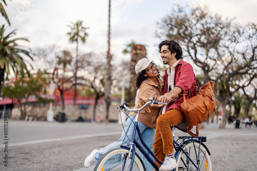 A happy couple with bike is having fun and embracing on the street.