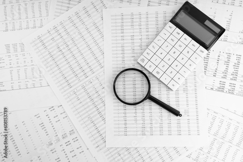 Calculator and magnifying glass on financial documents. Financial and business concept.