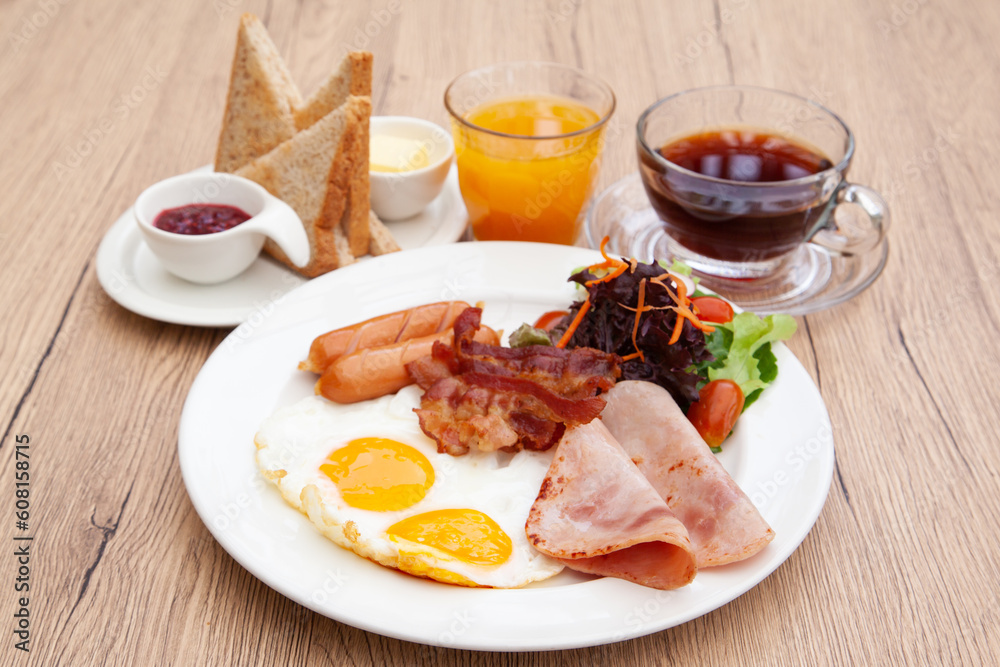 Full English breakfast set with sausage, egg, bacon, baked bean, ham, tomato and toast Full English breakfast set with sausage, egg, bacon, baked bean, ham, tomato and toast