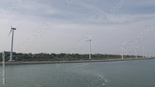 Wind power plants on sea shore near industrial area