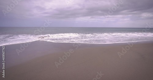 Paceful wave crashing in playa la Tejita beach in south Tenerife on a cloudy hot summer day. photo