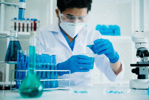 Scientist mixing chemical liquids in the chemistry lab. Researcher working in the chemical laboratory.