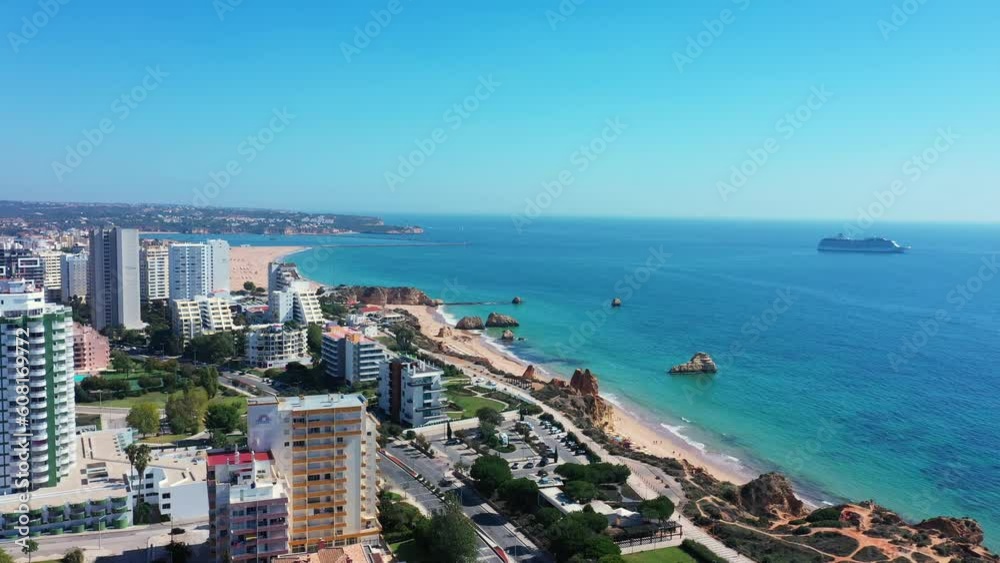 Tourist Portuguese city of Portimao aerial view on a sunny day. South Portugal Algarve. In background is a cruise liner on the sea. Tourist Portuguese city of Portimao aerial view on a sunny day. South Portugal Algarve. In background is a cruise liner on the sea.