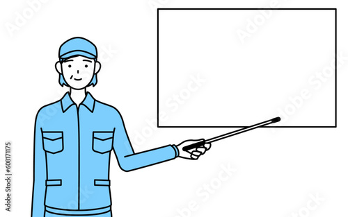 ホワイトボードを指示棒で指す帽子と作業着姿のシニア女性（経営者、管理職、上司）