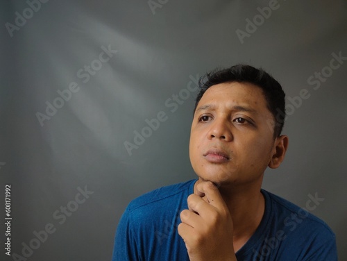 Young asian man shocked when he looking and pointing smartphone