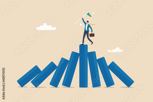 Winner take all, survive business competition or strength to overcome difficulty, economic crisis or recession, business winner concept, success businessman on stand strong bar graph domino collapse.