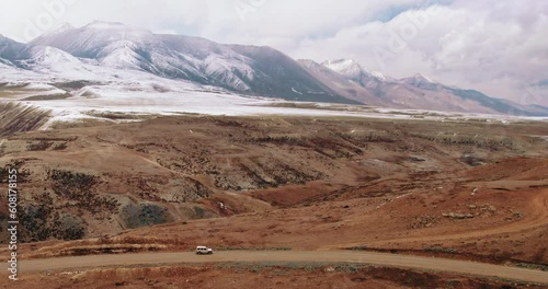 Thrilling drone shot: Jeep speeds through desert road of Korala Border at  Lomanthang, Upper Mustang, Nepal. Majestic mountain ranges and open plains ignite wanderlust. Perfect for adventure-seekers. photo