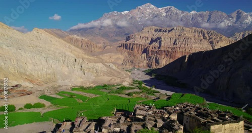 Drone shot captures beautiful Chusang village in Upper Mustang, Nepal. Unique structured dry mountains, snowy peaks, and a captivating blue sky backdrop. Explore the allure of Annapurna Area. photo