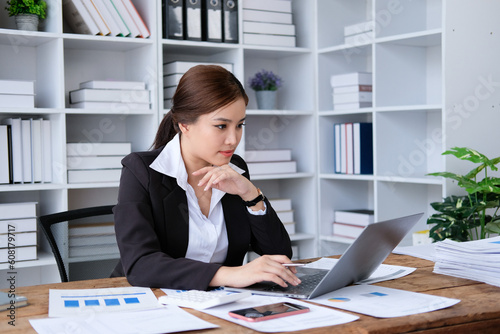 Asian businesswoman working at the office, Thinking and pay attention with the report in front of her desktop in the curious situation. Business and finance concepts.