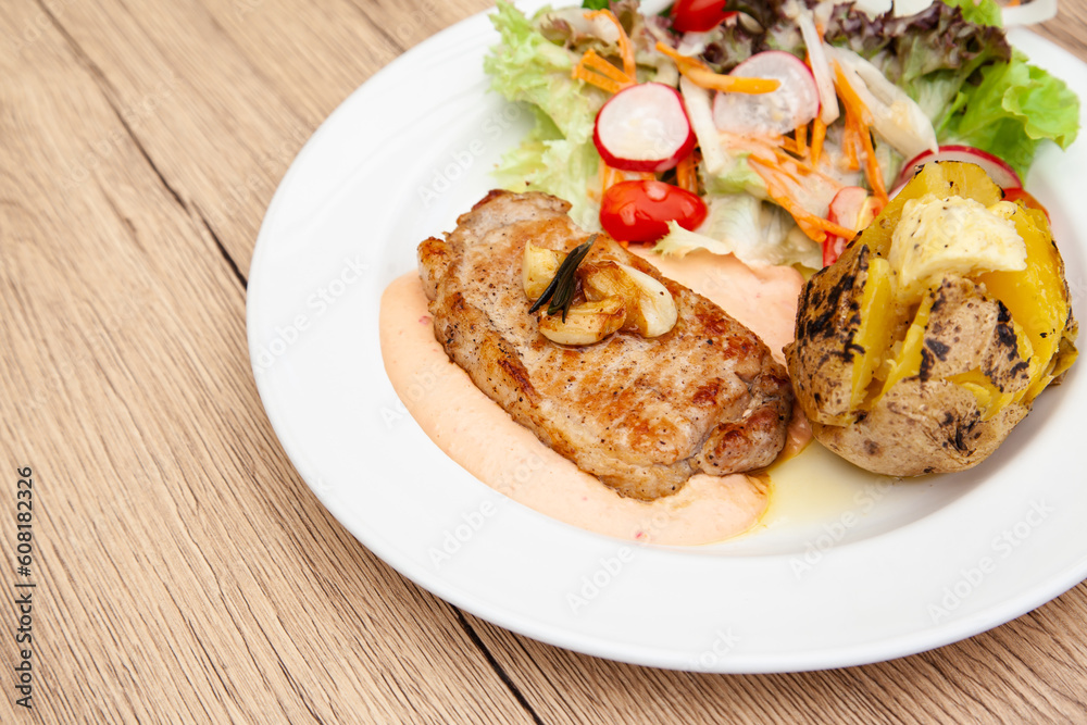Pork sirloin steak with baked potato and andalouse sauce Pork sirloin steak with baked potato and andalouse sauce