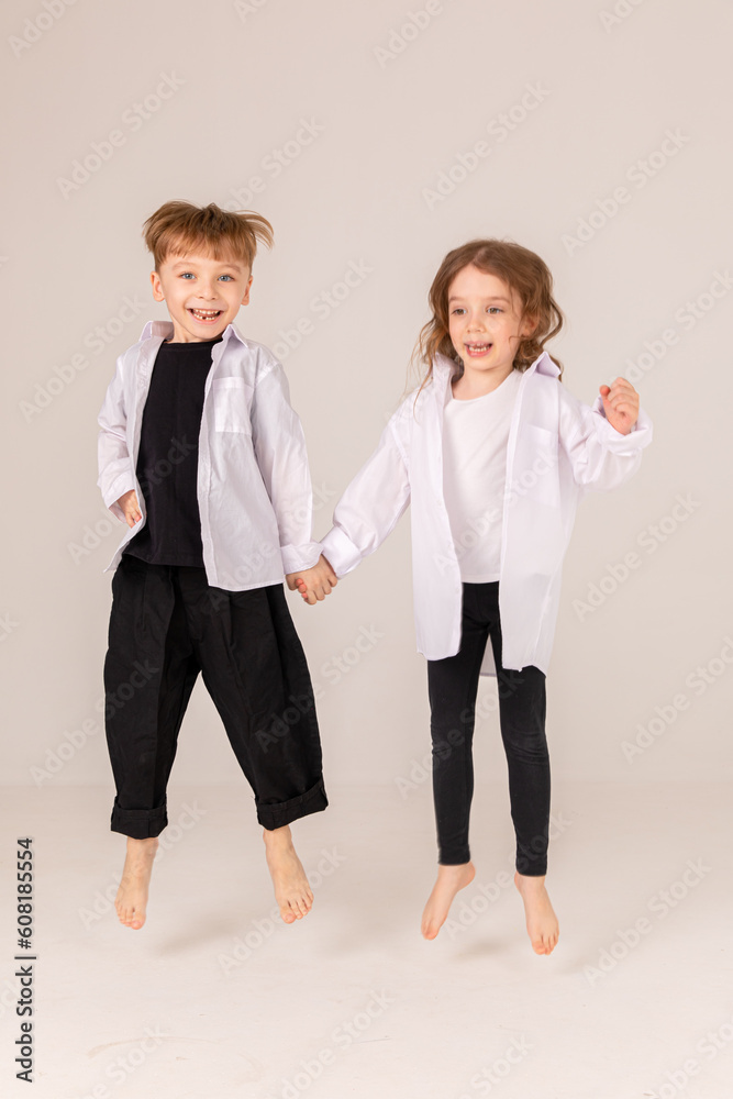 Fototapeta premium Cheerful and happy boy and girl brother and sister having fun on white background. Black and white style