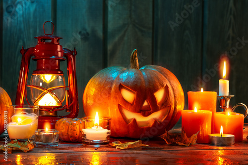 Halloween design concept. jack-o-lantern candles, lantern and leaves in dramatic lighting