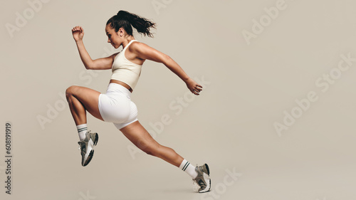 Fototapeta Naklejka Na Ścianę i Meble -  Sportswoman running and doing strength training in a studio