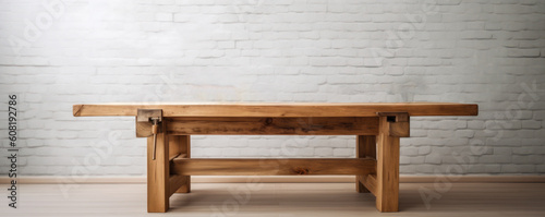 A classic wood woking table with thick table top and sturdy feet. In front of a white wall background. Extra wide format. Hand edited generative AI.  photo