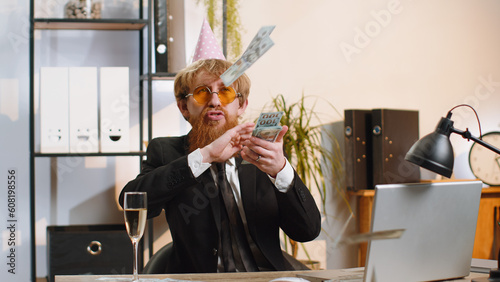 Εκτύπωση καμβά Cheerful rich young businessman working on laptop and wasting throwing money to camera more tips earnings big profit success win lottery shopping