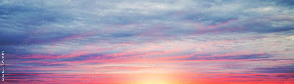 Real amazing panoramic sunrise or sunset sky with gentle colorful clouds