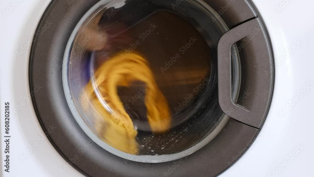 washing machine , laundry being washed washing machine , laundry being washed