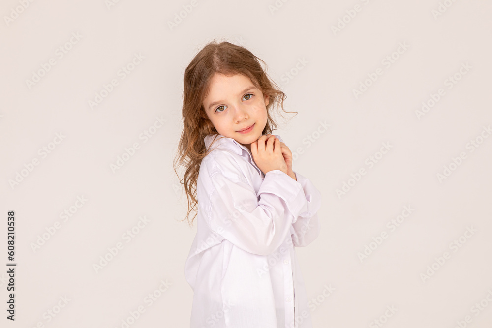 Smiling cute little blonde girl in white shirt on white background. Copy space. Mock up Smiling cute little blonde girl in white shirt on white background. Copy space. Mock up