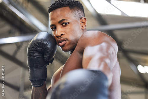 African man, boxing and punch in portrait for fitness, focus or training at gym for growth, goal and competition. African guy, boxer and gloves for exercise, wellness and martial arts club for sports © Nkalipho M/peopleimages.com