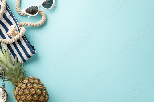 Wall Mural Immerse yourself in the essence of summer vacation with this captivating top-down view of sunglasses, fruit, bag, on a tranquil pastel blue surface