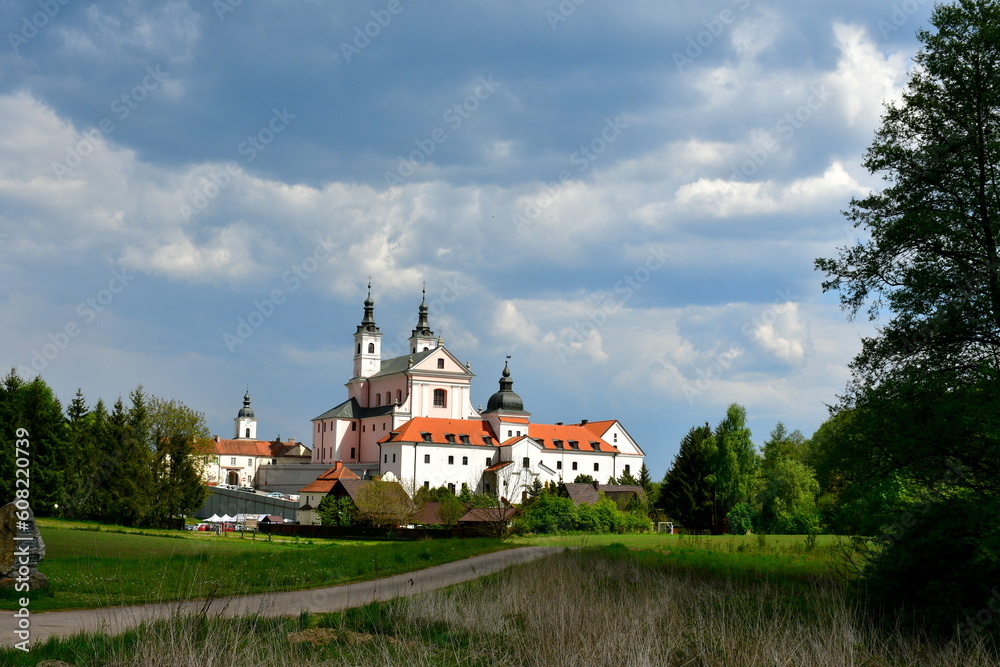 A view of an old monastery used to train and house monks and priests protected by a strong red brick and concrete wall and located next to a massive moat seen in Poland in summer