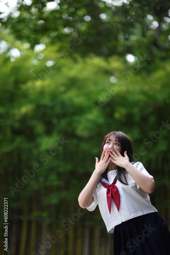 Japanese high school student with happy and pointing on copy space in bamboo background