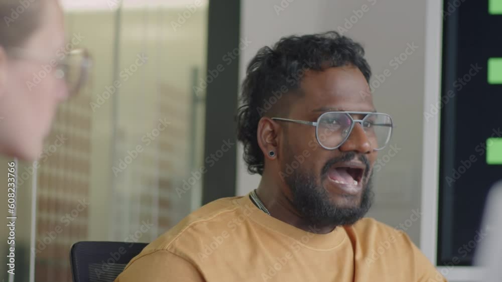 Over the shoulder shot of multiracial man having discussion with female colleague during business meeting in office Over the shoulder shot of multiracial man having discussion with female colleague during business meeting in office