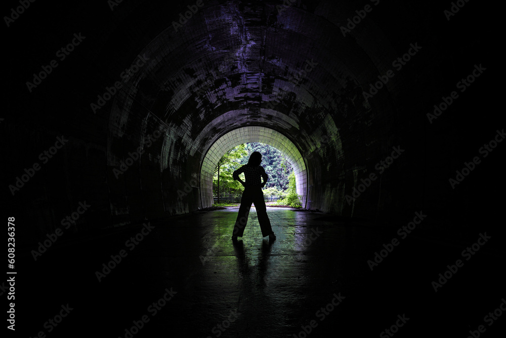 古いトンネルの中に立つ女性のシルエット