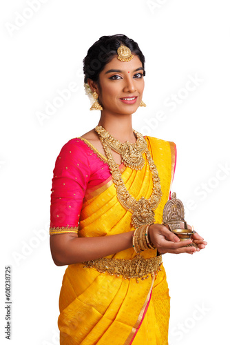 Beautiful happy Indian young woman in saree holding Deepa (oil lamp ) isolated on white.	
