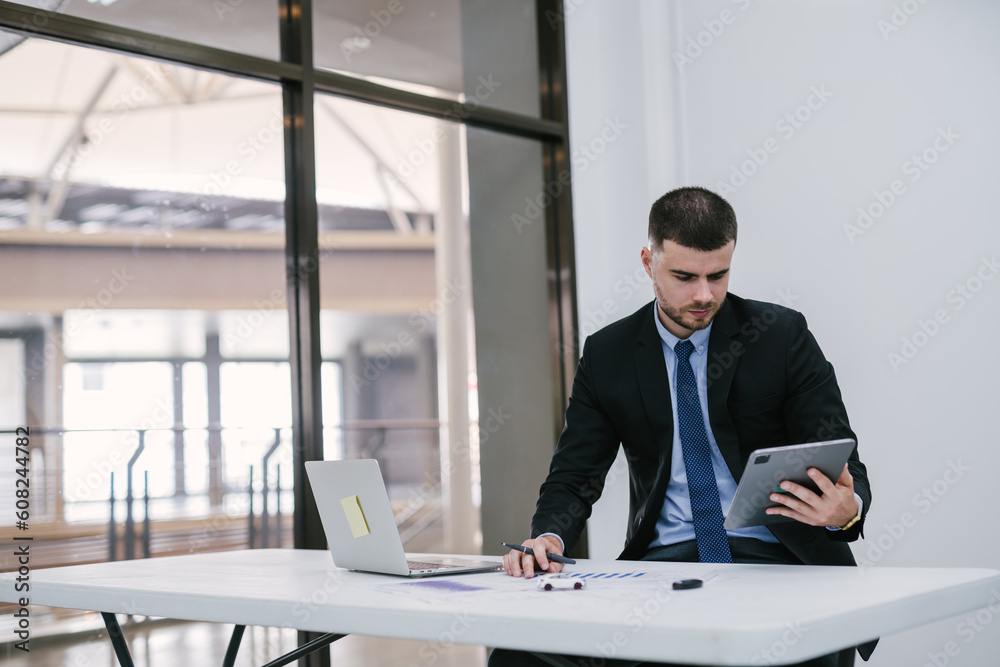 A male handsome caucasian working at office and checking toy cars on desk and car keys. Dealership and online sales concept. A male handsome caucasian working at office and checking toy cars on desk and car keys. Dealership and online sales concept.