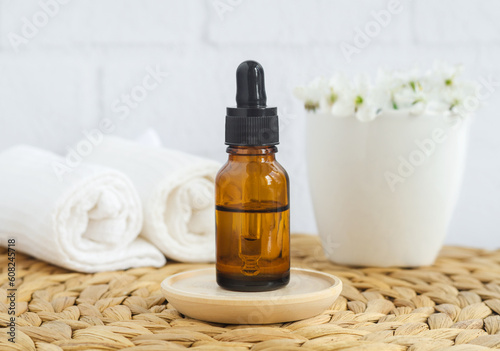 Small glass bottle with essential oil perfume, essence, anti-aging cosmetic face serum). Aromatherapy, natural skin care, homemade spa and herbal medicine concept. Copy space.