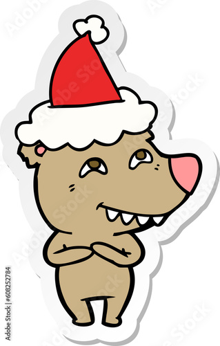 hand drawn sticker cartoon of a bear showing teeth wearing santa hat © lineartestpilot