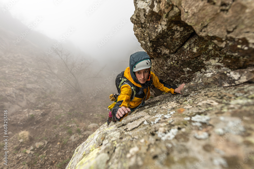 Obraz premium woman climbing high mountains in the Pyrenees dramatic sunset sky, valley with trees, high peaks,