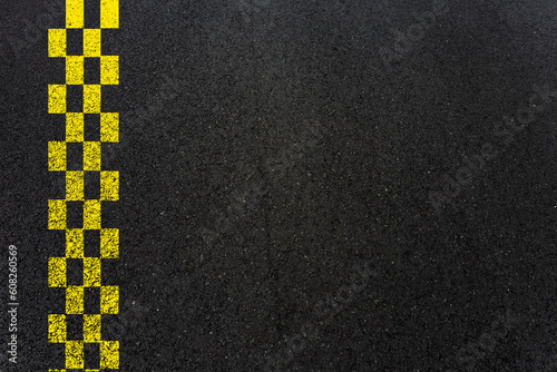Bandes jaunes en damier sur asphalte 