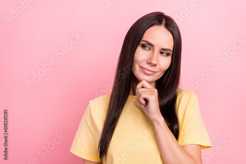 Photo of suspicious pretty woman dressed yellow t-shirt arm chin looking empty space isolated pink color background