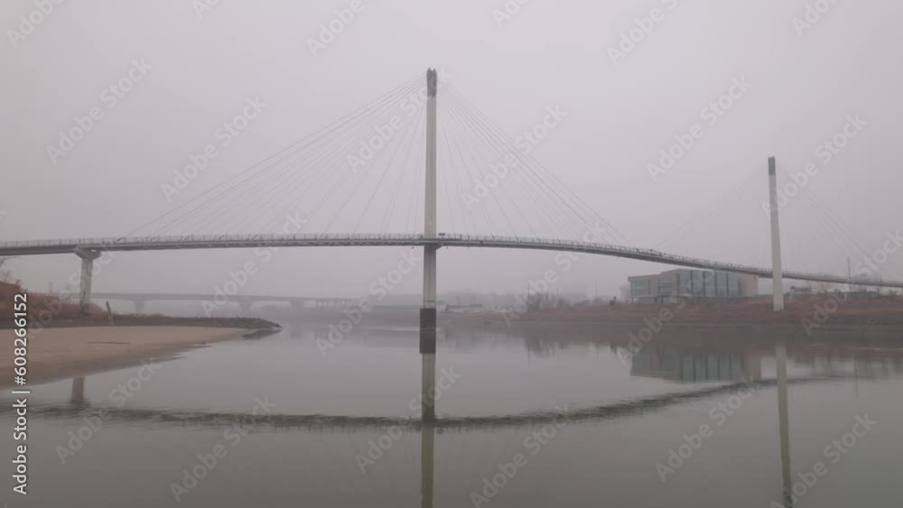 Bob Kerrey Pedestrian Bridge in Omaha, Nebraska covered in fog and cloudy sky on a cold, autumn day Bob Kerrey Pedestrian Bridge in Omaha, Nebraska covered in fog and cloudy sky on a cold, autumn day