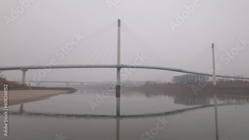 Bob Kerrey Pedestrian Bridge in Omaha, Nebraska covered in fog and cloudy sky on a cold, autumn day photo