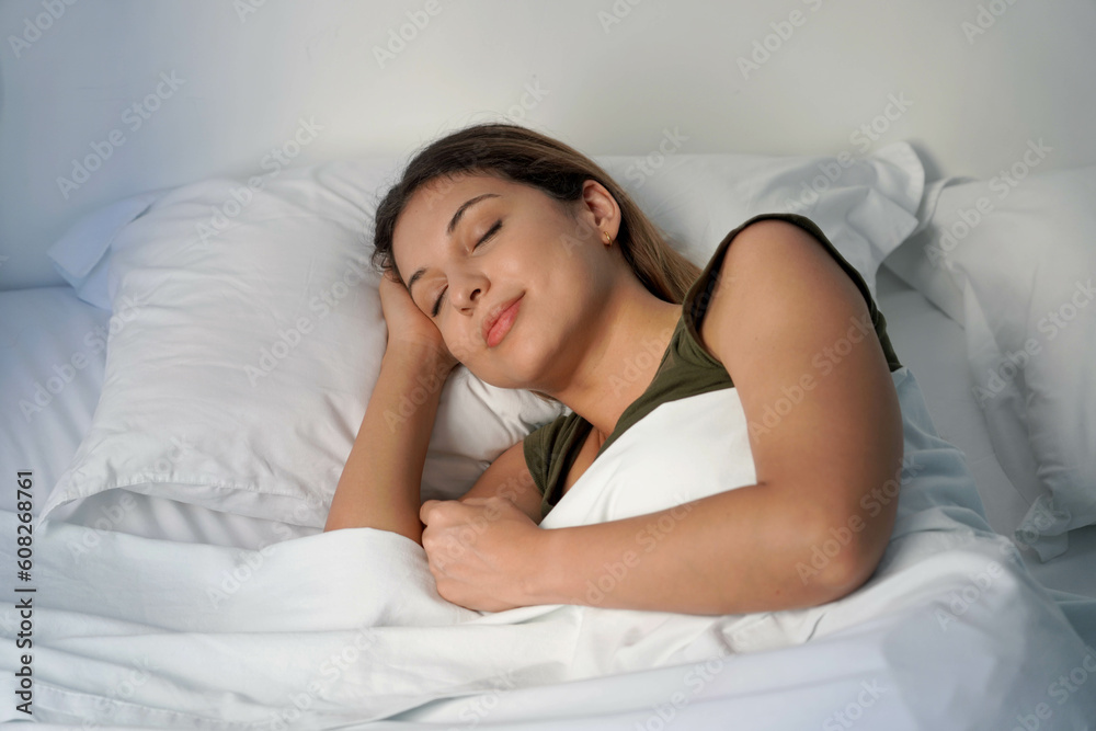 Close-up of Hispanic woman sleeping profoundly in white sheets at night Close-up of Hispanic woman sleeping profoundly in white sheets at night