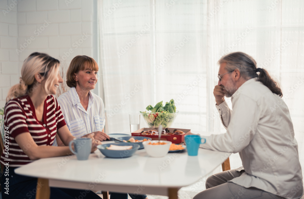 Members of the family from multiple generations enjoy quality time together by eating, snacking, chatting, discussing, learning about each other's interests, and strengthening stronger relationships. Members of the family from multiple generations enjoy quality time together by eating, snacking, chatting, discussing, learning about each other's interests, and strengthening stronger relationships.