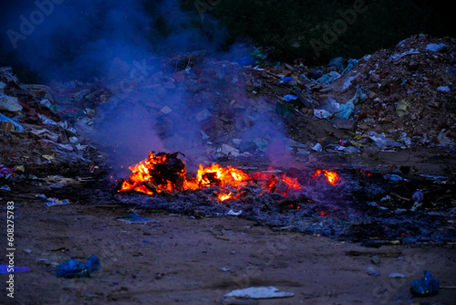 Unscientific burning of garbage in a public place in a late evening photo