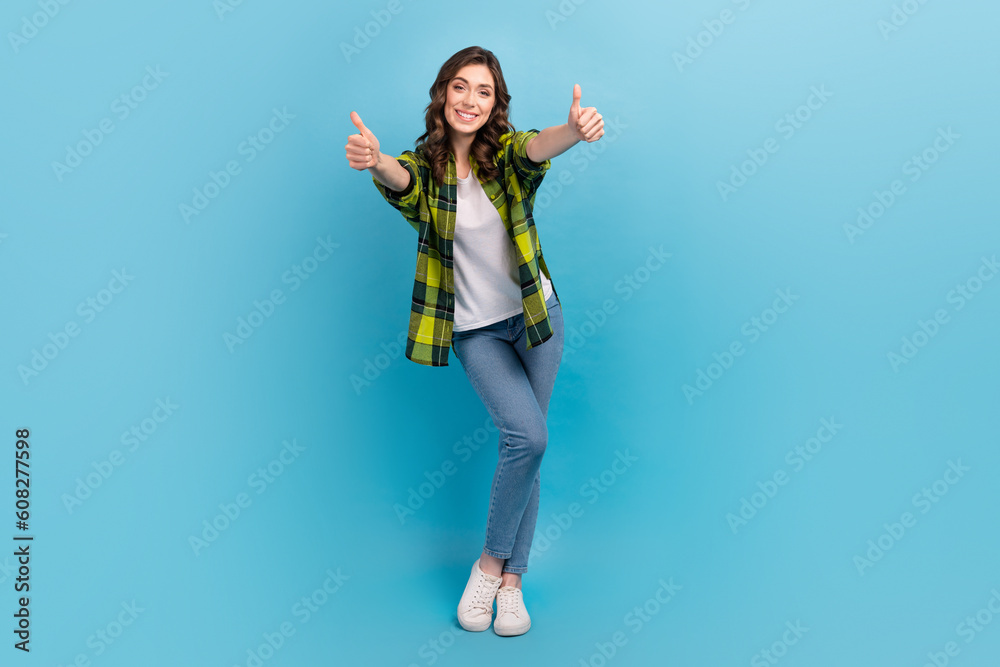 Full length photo of positive lovely person arms fingers demonstrate thumb up isolated on blue color background Full length photo of positive lovely person arms fingers demonstrate thumb up isolated on blue color background