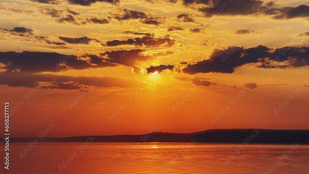 A solar eclipse during a mesmerizing fiery sunset. Majestic sunset or sunrise landscape. Sunset with reflection in the water. The sun and clouds were reflected in the water. Fiery sunset. Russia A solar eclipse during a mesmerizing fiery sunset. Majestic sunset or sunrise landscape. Sunset with reflection in the water. The sun and clouds were reflected in the water. Fiery sunset. Russia