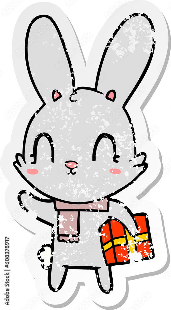 distressed sticker of a cute cartoon rabbit with christmas present distressed sticker of a cute cartoon rabbit with christmas present