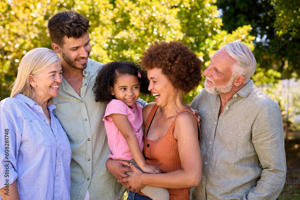 Portrait Of Multi-Generation Family Standing In Garden Smiling At Camera Portrait Of Multi-Generation Family Standing In Garden Smiling At Camera