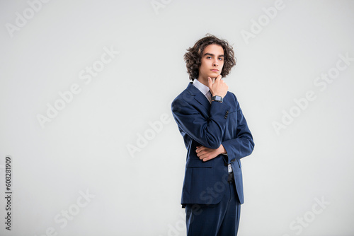 Portrait of a handsome young man in a dark blue business suit on a white background.