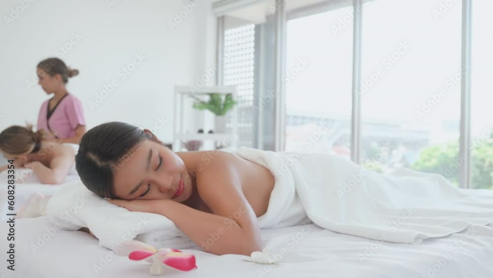 Young woman resting on massage bed after a massage at spa salon. Young woman resting on massage bed after a massage at spa salon.