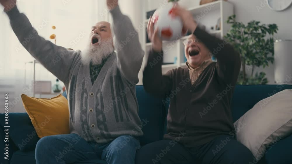 Two senior men football fans watching the game, contemporary grandpas, victory Two senior men football fans watching the game, contemporary grandpas, victory