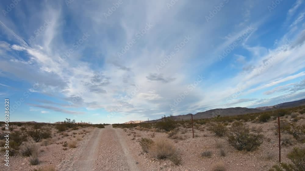 Driving POV on the dirt road through the Nevada desert, surrounded by sagebrush and more dirt on a hot summer day. USA road trip concept Driving POV on the dirt road through the Nevada desert, surrounded by sagebrush and more dirt on a hot summer day. USA road trip concept